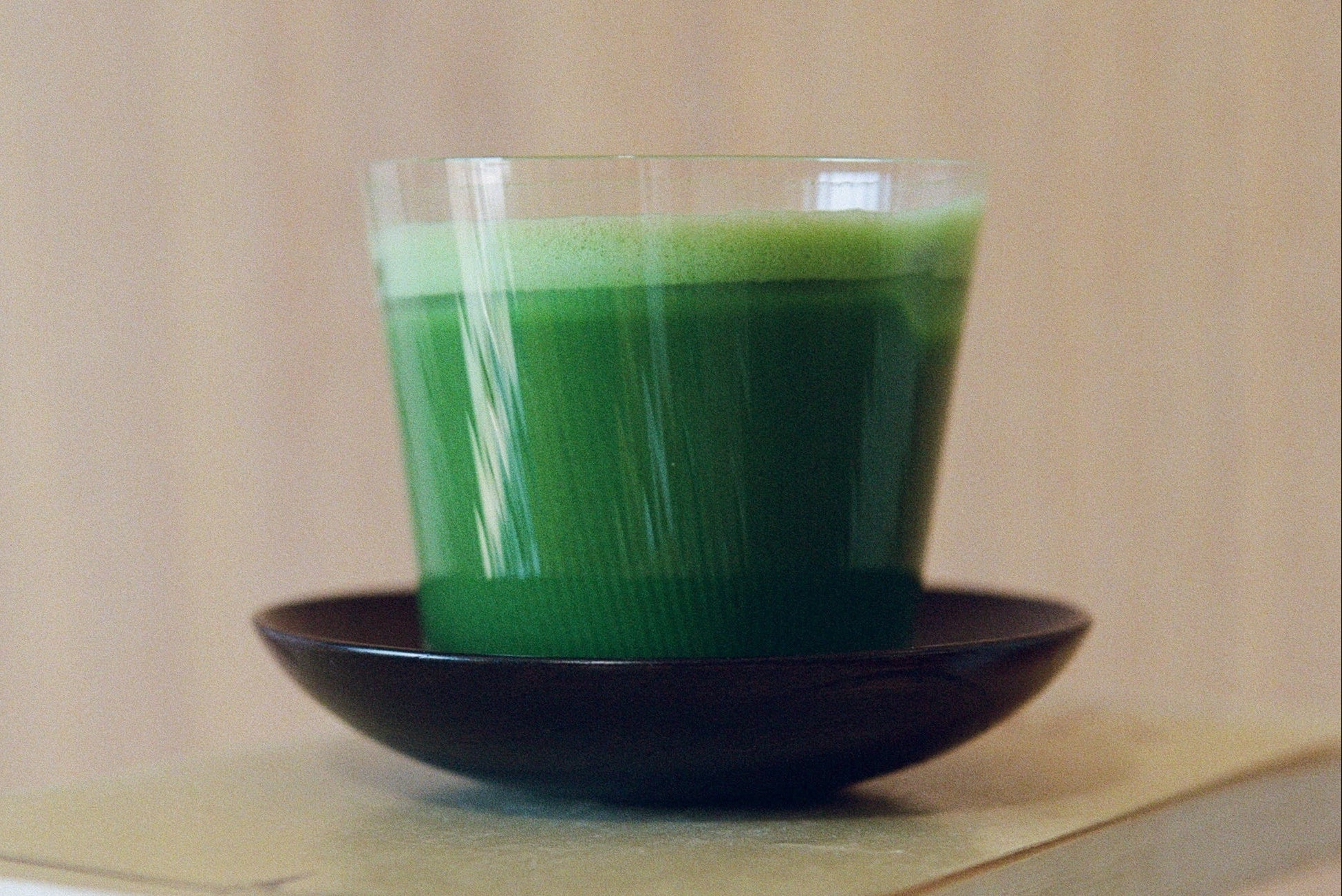 Matcha in a glass on a saucer